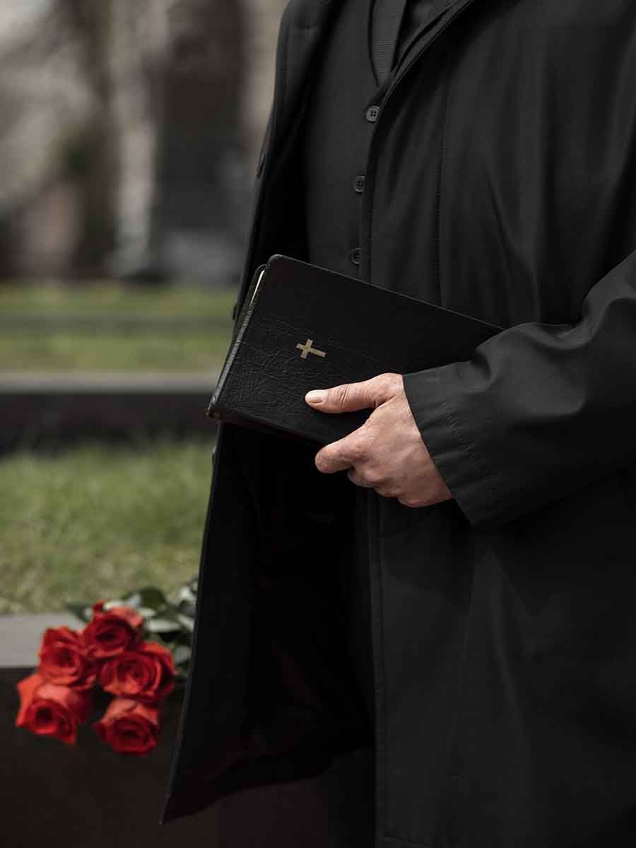 man-with-flowers-bible-cemetery-scaled
